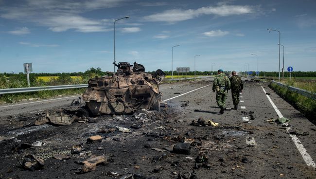 Бойцы ополчения у сожженной бронетехники украинской армии в поселке Роскошное