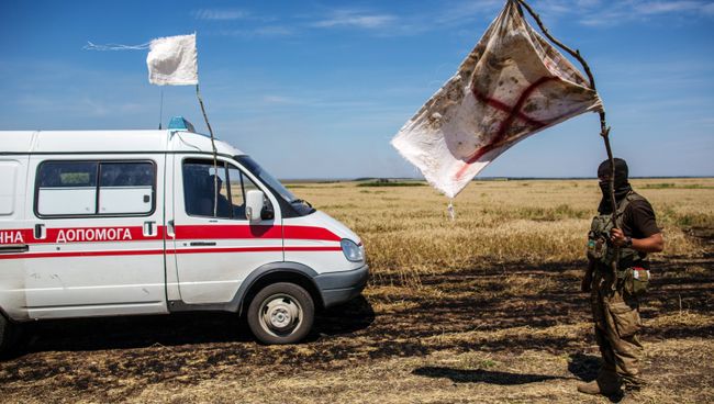Украинский военный с белым флагом во время передачи убитых на нейтральной территории вблизи поселка Диброво Украинский военный с белым флагом во время передачи убитых на нейтральной территории вблизи поселка Диброво