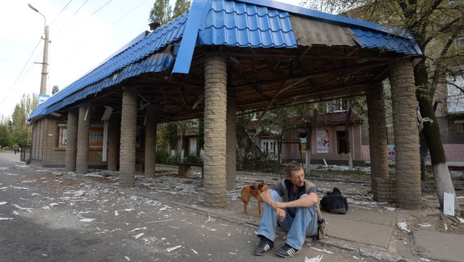 Мужчина сидит возле разрушенной остановки в Горловке Мужчина сидит возле разрушенной остановки в Горловке