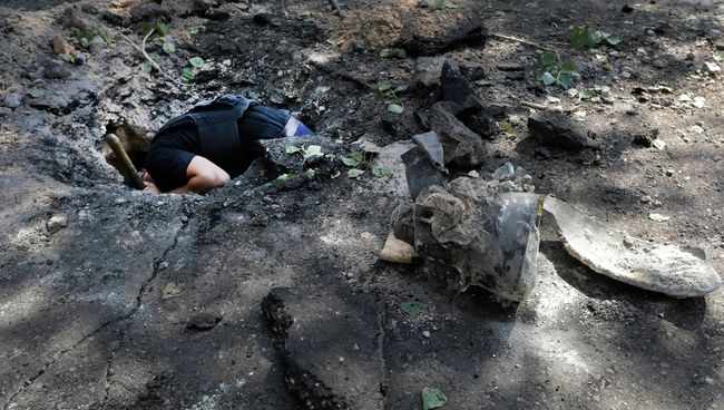Сапер обследует воронку на месте падения снаряда. Архивное фото