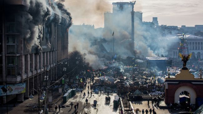 Дым от пожаров и сторонники оппозиции на площади Независимости в Киеве, где начались столкновения митингующих и сотрудников милиции. 2014 год. Архивное фото Дым от пожаров и сторонники оппозиции на площади Независимости в Киеве, где начались столкновения митингующих и сотрудников милиции. 2014 год. Архивное фото