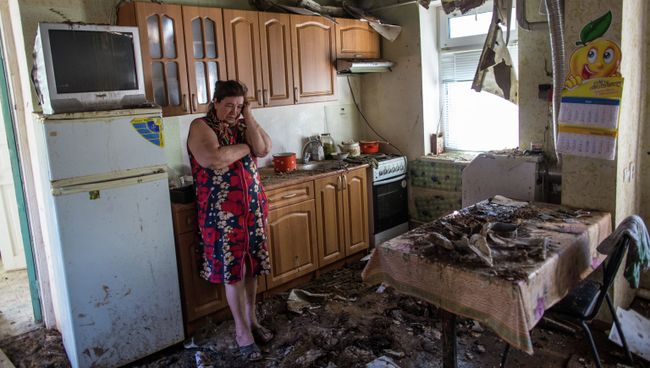 Женщина в доме, пострадавшем в результате артобстрела на окраине Славянска