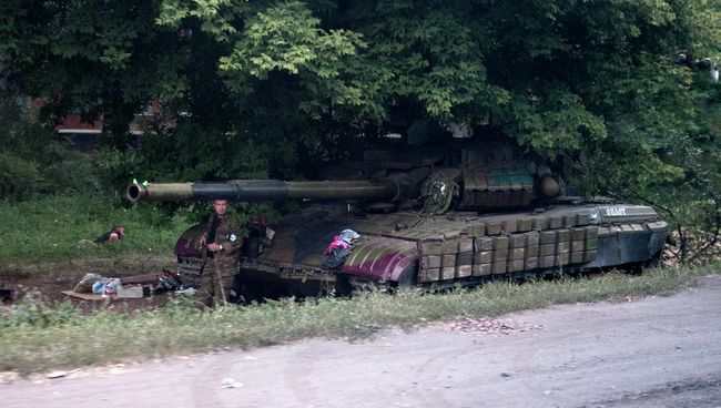 Боец ополчения возле танка в Донецкой области. Архивное фото Боец ополчения возле танка в Донецкой области. Архивное фото