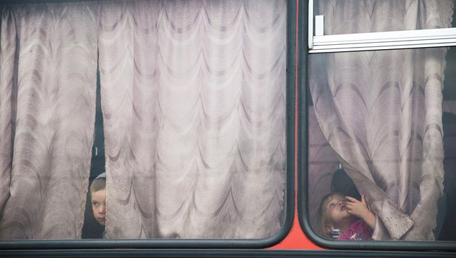 Дети в автобусе перед отъездом из лагеря для беженцев в Донецке Ростовской области Дети в автобусе перед отъездом из лагеря для беженцев в Донецке Ростовской области
