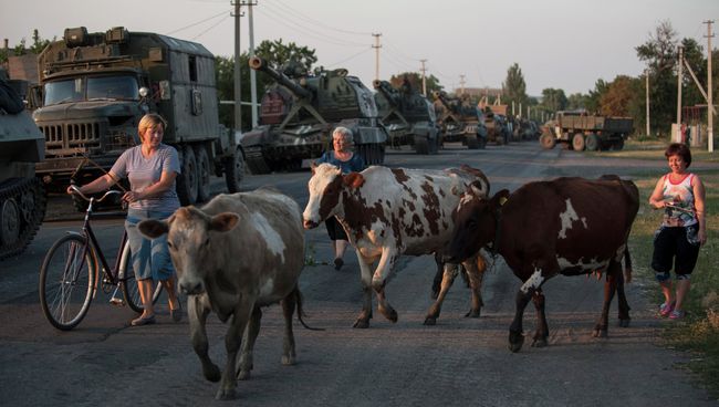 Местные жители на фоне военной техники украинской армии в городе Иловайске. Архивное фото Местные жители на фоне военной техники украинской армии в городе Иловайске. Архивное фото
