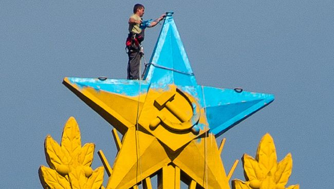 Рабочий закрашивает звезду на шпиле высотного здания на Котельнической набережной. Архивное фото