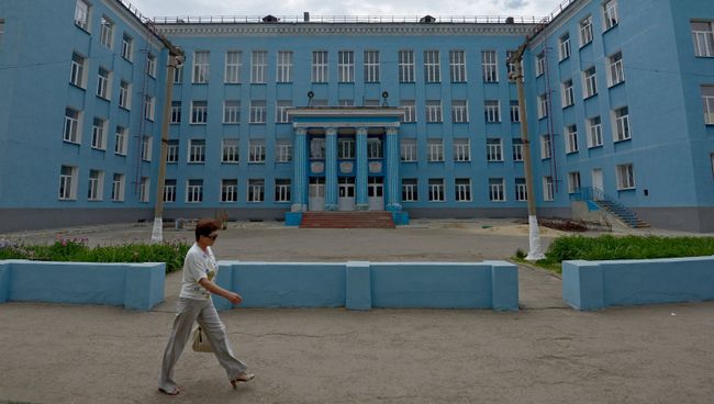 Прохожая у здания школы в городе Луганске. Архивное фото