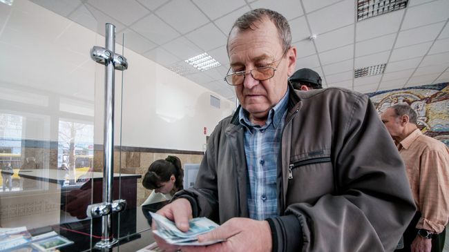 Мужчина получает пенсию в почтовом отделении. Архивное фото Мужчина получает пенсию в почтовом отделении. Архивное фото