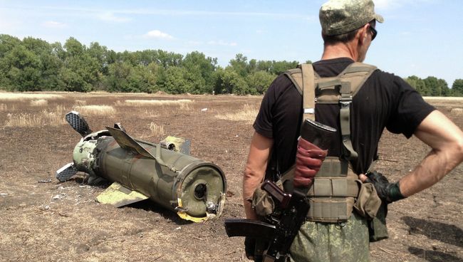 Ополченец Донецкой народной республики (ДНР) у ракеты Точка-У, упавшей в окрестностях города Снежное. Архивное фото
