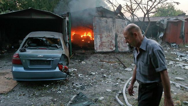 Житель у горящего в результате обстрела Украинскими военными строения в Донецке Житель у горящего в результате обстрела Украинскими военными строения в Донецке