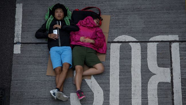 Сторонники протестного движения Occupy Central спят на проезжей части в районе Admiralty в Гонконге Сторонники протестного движения Occupy Central спят на проезжей части в районе Admiralty в Гонконге