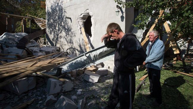 Жители Донецка у своего дома, разрушенного после обстрела. Украина, 7 октября 2014. Архивное фото Жители Донецка у своего дома, разрушенного после обстрела. Украина, 7 октября 2014. Архивное фото