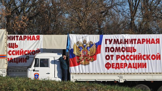 Сотрудник МЧС РФ у автомашины во время подготовки к отправке четвертой гуманитарной колонны на Юго-Восток Украины в поселке Ковалевка Ростовской области. Сотрудник МЧС РФ у автомашины во время подготовки к отправке четвертой гуманитарной колонны на Юго-Восток Украины в поселке Ковалевка Ростовской области.