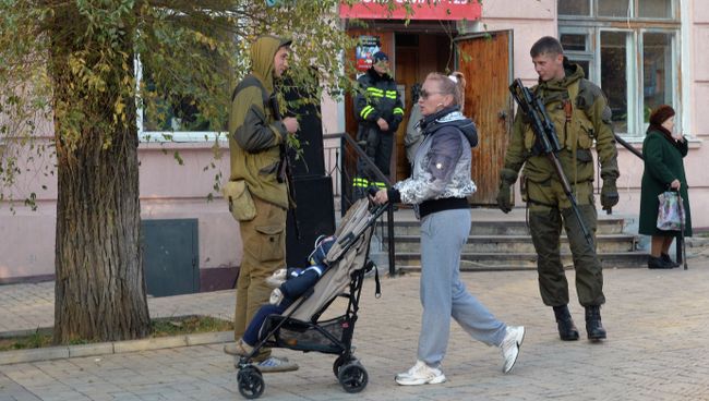 Жительница Донецка и ополченцы перед входом в избирательный участок № 125 на выборах в ДНР. Архивное фото