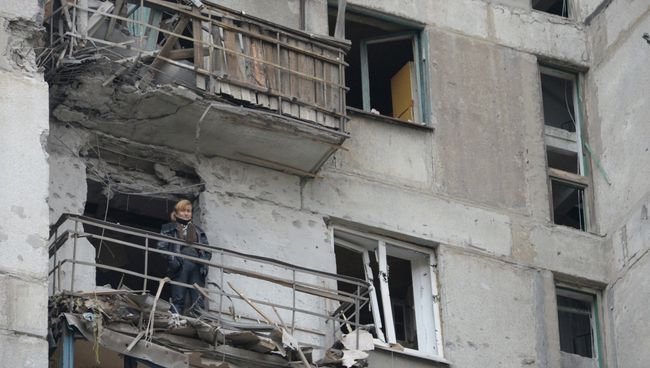 Женщина на балконе дома подвергшегося обстрелу украинскими военными Женщина на балконе дома подвергшегося обстрелу украинскими военными