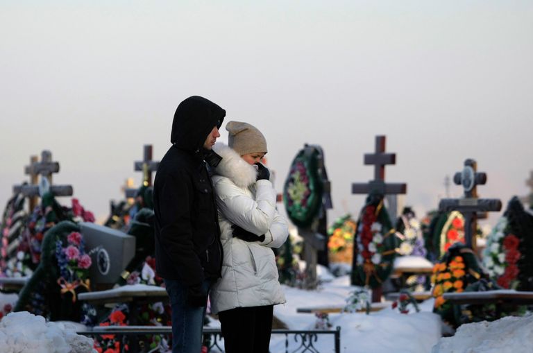 Родственники у могил погибших в результате пожара в клубе Хромая лошадь в Перми