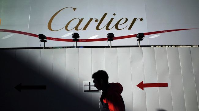 Прохожий на фоне рекламного баннера Cartier