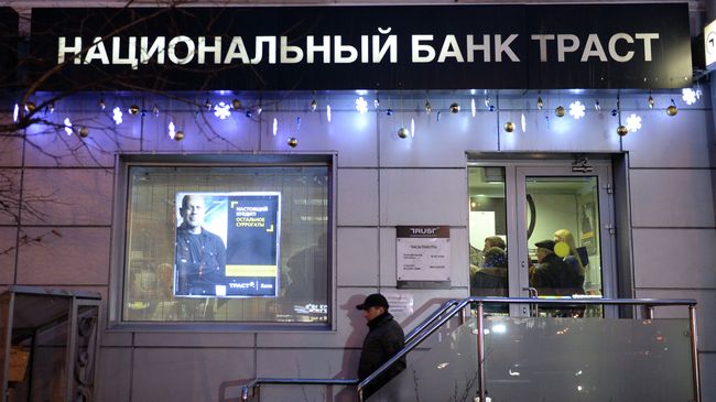 Клиент выходит из офиса банка Траст в Москве Клиент выходит из офиса банка Траст в Москве