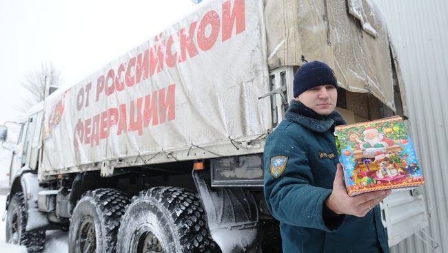 Сотрудник МЧС демонстрирует детский рождественский подарок во время формирования одиннадцатого гуманитарного конвоя для Донбасса Сотрудник МЧС демонстрирует детский рождественский подарок во время формирования одиннадцатого гуманитарного конвоя для Донбасса