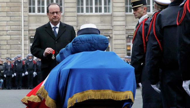 Президент Франции Франсуа Олланд перед гробом офицера полиции, погибшего в результате теракта в Париже