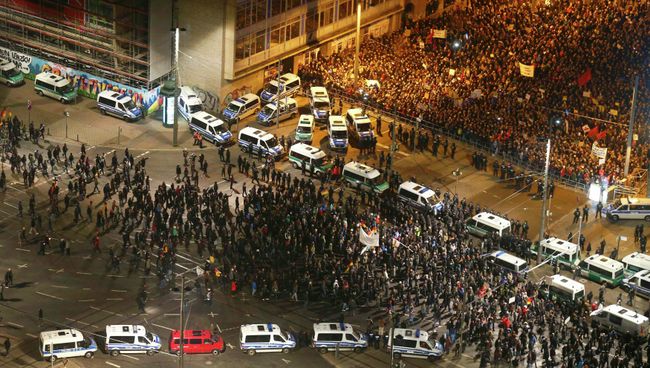 Участники антиисламского движения проходят мимо толпы своих противников во время митинга в Лейпциге Участники антиисламского движения проходят мимо толпы своих противников во время митинга в Лейпциге