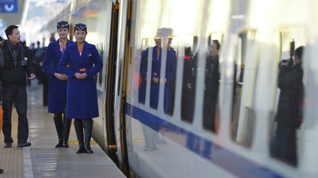 Китайские проводницы возле скоростного поезда в Урумчи, Китай. Архивное фото