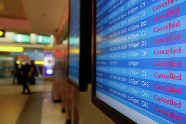 Табло с отмененными из-за снегопада рейсами в аэропорту Ла Гуардия, США Табло с отмененными из-за снегопада рейсами в аэропорту Ла Гуардия, США