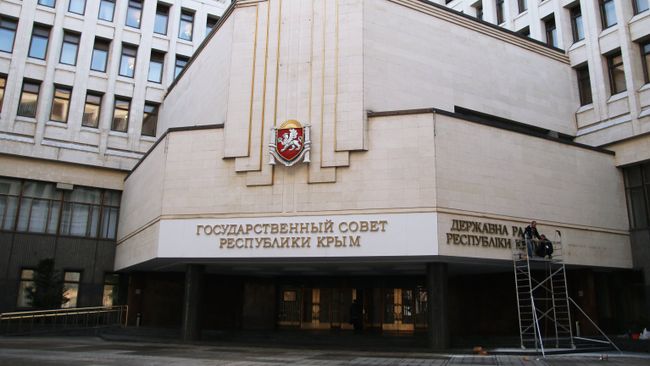 Рабочие крепят на фасад Государственного совета Республики Крым название парламента на украинском языке в городе Симферополе. Архивное фото