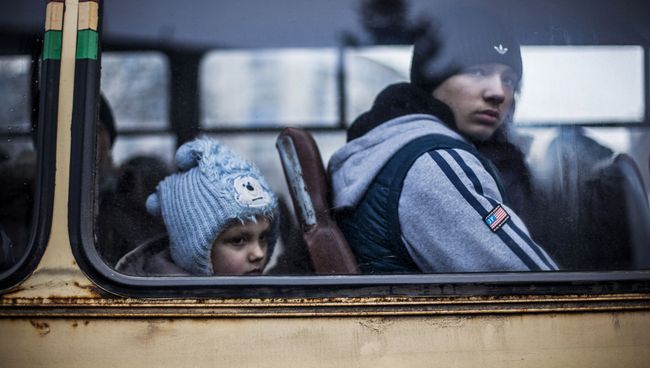 Люди сидят в автобусе, чтобы покинуть зону военного конфликта. Архивное фото Люди сидят в автобусе, чтобы покинуть зону военного конфликта. Архивное фото