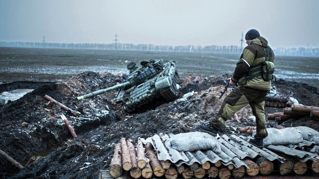 Ополченец стоит у танка украинской армии в Донецкой области. Архивное фото Ополченец стоит у танка украинской армии в Донецкой области. Архивное фото