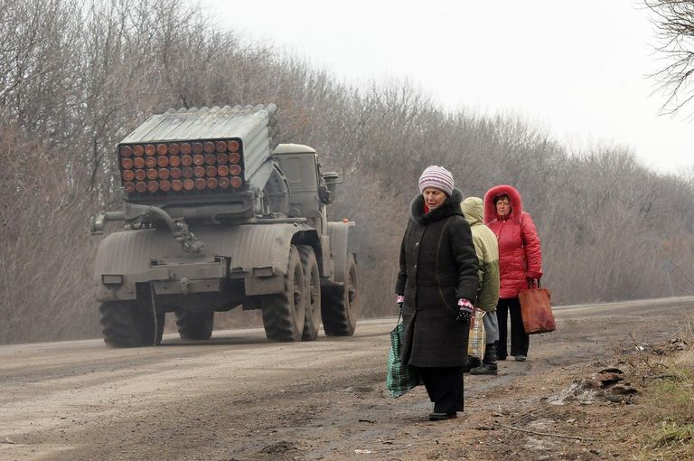 Жители Дебальцево на обочине дороги, по которой следует военная техника Жители Дебальцево на обочине дороги, по которой следует военная техника