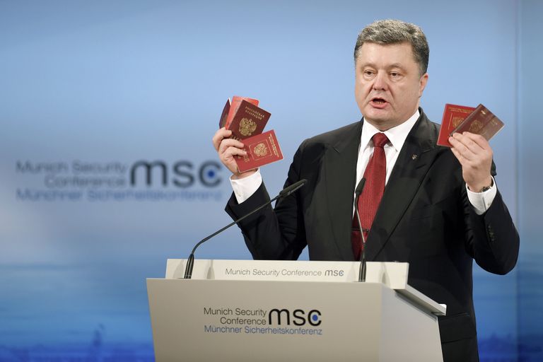 Президент Украины Петр Порошенко демонстрирует на Мюнхенской конференции паспорт и военный билет, которые якобы принадлежат российским военным