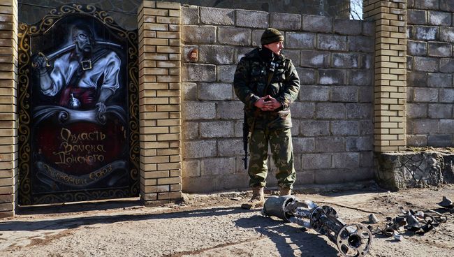 Ополченец возле обломков снаряда. Архивное фото Ополченец возле обломков снаряда. Архивное фото