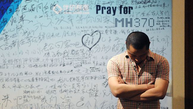 Мужчина стоит на фоне стенда, посвященного пассажирам пропавшего рейса MH370 компании Malaysia Airlines. Архивное фото Мужчина стоит на фоне стенда, посвященного пассажирам пропавшего рейса MH370 компании Malaysia Airlines. Архивное фото