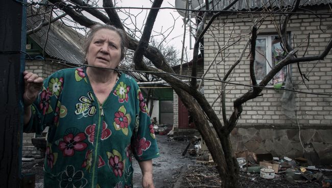 Жительница Донбасса у дома, пострадавшего во время боевых действий. Архивное фото Жительница Донбасса у дома, пострадавшего во время боевых действий. Архивное фото