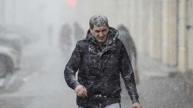 Прохожий на улице во время снегопада в Москве. Архивное фото Прохожий на улице во время снегопада в Москве. Архивное фото