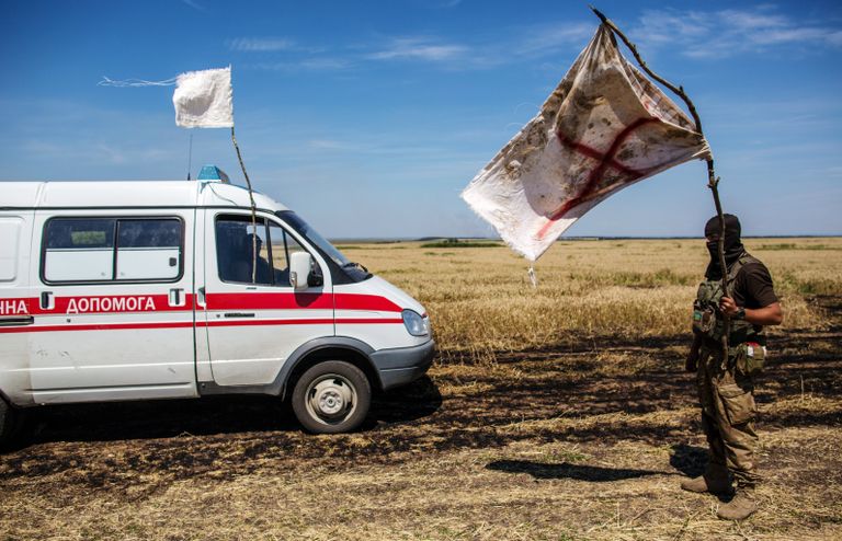 Украинский военный с белым флагом во время передачи убитых на нейтральной территории вблизи поселка Диброво возле российско-украинской границы в Донецкой области, 29 июля 2014 Украинский военный с белым флагом во время передачи убитых на нейтральной территории вблизи поселка Диброво возле российско-украинской границы в Донецкой области, 29 июля 2014