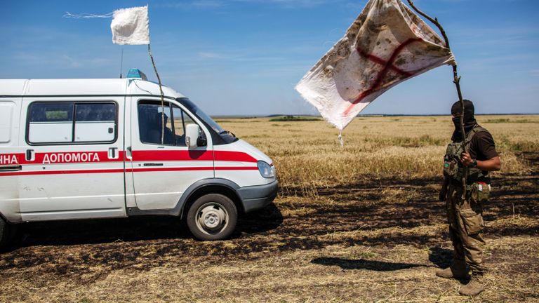Украинский военный с белым флагом во время передачи убитых на нейтральной территории вблизи поселка Диброво возле российско-украинской границы в Донецкой области, 29 июля 2014 Украинский военный с белым флагом во время передачи убитых на нейтральной территории вблизи поселка Диброво возле российско-украинской границы в Донецкой области, 29 июля 2014