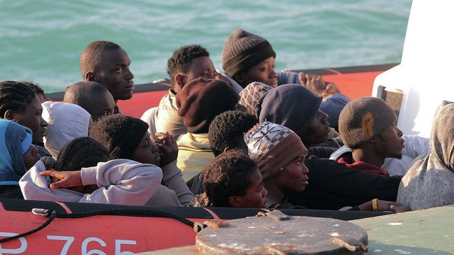 Нелегальные мигранты, спасенные после крушения судна в водах Ливии, на лодке береговой охраны Италии Нелегальные мигранты, спасенные после крушения судна в водах Ливии, на лодке береговой охраны Италии