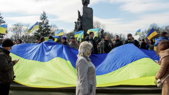 Участники демонстрации держат флаг Украины у памятника Тарасу Шевченко в Харькове Участники демонстрации держат флаг Украины у памятника Тарасу Шевченко в Харькове
