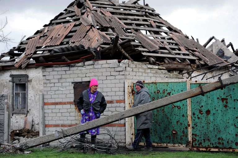 Жительницы поселка Никишино рядом с пострадавшим в результате обстрелов домом Жительницы поселка Никишино рядом с пострадавшим в результате обстрелов домом