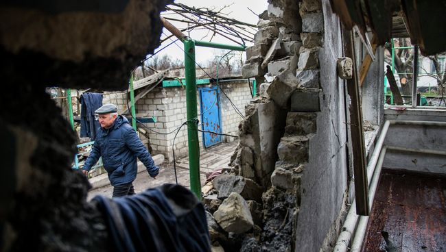 Мужчина рядом с разрушенным домом в селе Никишино Донецкой области. Архивное фото Мужчина рядом с разрушенным домом в селе Никишино Донецкой области. Архивное фото