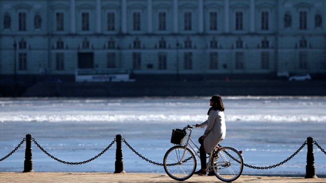 Девушка едет на велосипеде по Набережной Невы в Санкт-Петербурге. Архивное фото. Девушка едет на велосипеде по Набережной Невы в Санкт-Петербурге. Архивное фото.