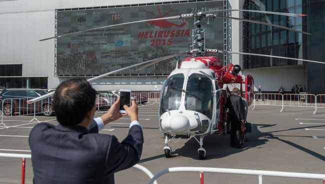 Посетитель фотографирует вертолет КА-226Т на HeliRussia 2015. Архивное фото Посетитель фотографирует вертолет КА-226Т на HeliRussia 2015. Архивное фото