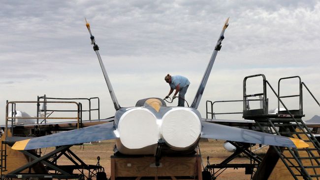 Военнослужащий покрывает водонепроницаемой краской американский истребитель-бомбардировщик F-18 на авиабазе ВВС США Девис-Монтен в Тусоне, Аризона. Архивное фото Военнослужащий покрывает водонепроницаемой краской американский истребитель-бомбардировщик F-18 на авиабазе ВВС США Девис-Монтен в Тусоне, Аризона. Архивное фото