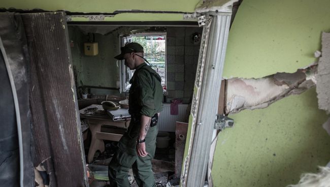 Ополченец Донецкой народной республики осматривает дом, разрушенный в результате обстрела украинскими силовиками в Горловке Ополченец Донецкой народной республики осматривает дом, разрушенный в результате обстрела украинскими силовиками в Горловке
