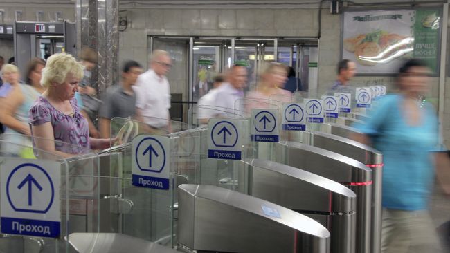 Пассажиры проходят через турникеты на станции метро Киевская