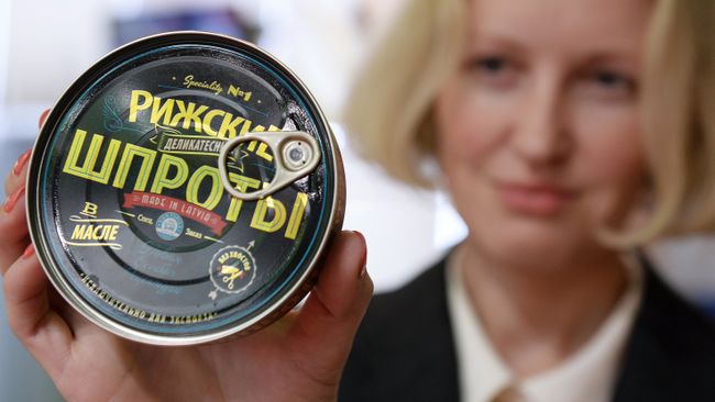 Девушка демонстрирует рыбные консервы Рижские шпроты Вентспиллского рыбоконсервного комбината Девушка демонстрирует рыбные консервы Рижские шпроты Вентспиллского рыбоконсервного комбината