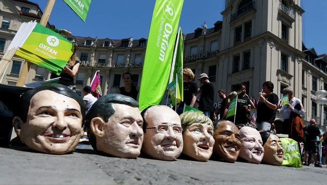 Участники акции протеста в Мюнхене приуроченной к саммиту G-7 с муляжами голов мировых лидеров Участники акции протеста в Мюнхене приуроченной к саммиту G-7 с муляжами голов мировых лидеров