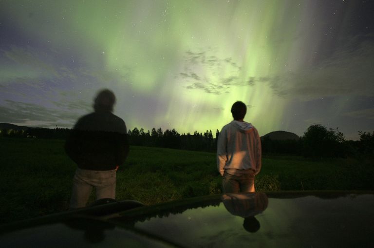 Люди смотрят на северное сияние в Швеции Люди смотрят на северное сияние в Швеции